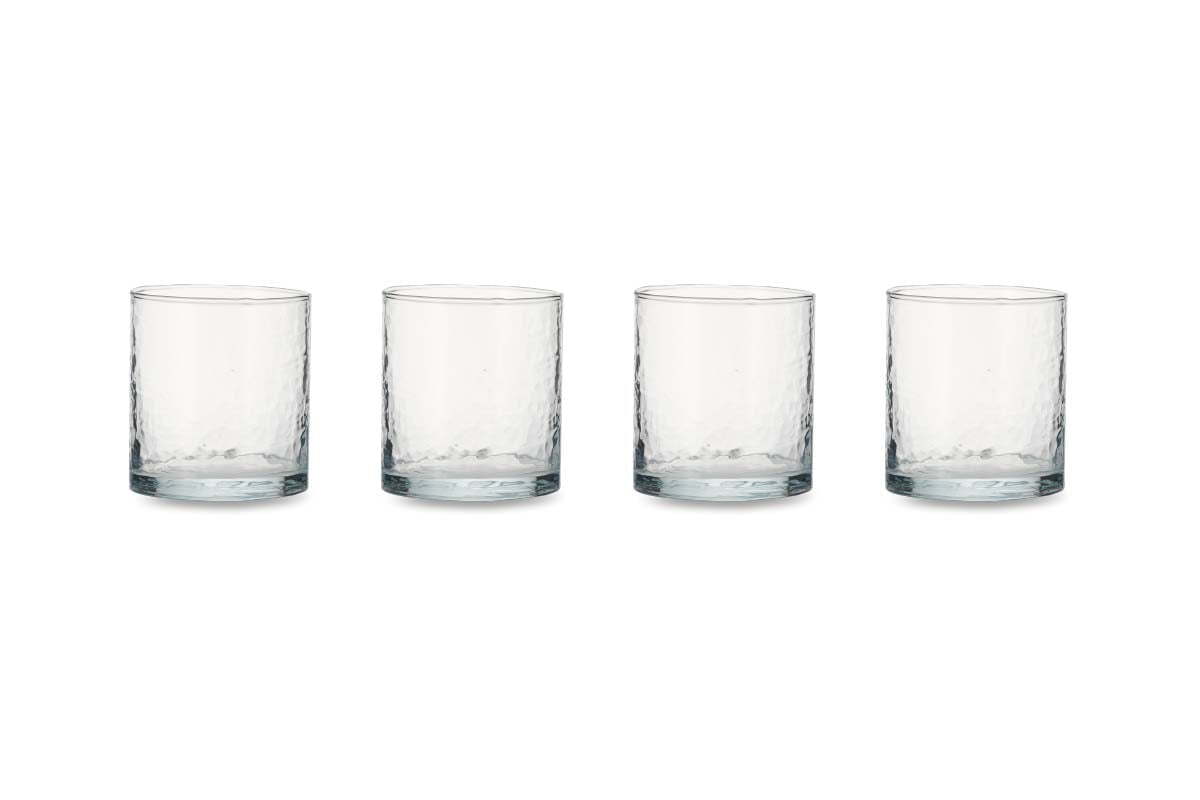 The nkuku Yala Hammered Tumbler set includes four identical clear glass tumblers with a subtle dimpled texture, neatly arranged in a row on a white background for an organic, elegant look.