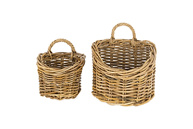 The nkuku Zawar Rattan Hanging Baskets - Natural (Set of 2) are shown against a white background, featuring sturdy curved handles. The smaller basket is on the left; the larger, right basket is great for pantry storage or hanging displays.