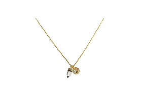 The Pandita Charm Necklace by nkuku features a small clear quartz point with a gold cap and a round engraved gold charm, both suspended together. This unique handmade jewelry piece is shown against a plain white background.
