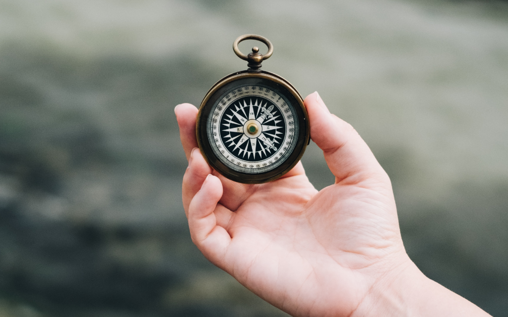 Hand holding a compass