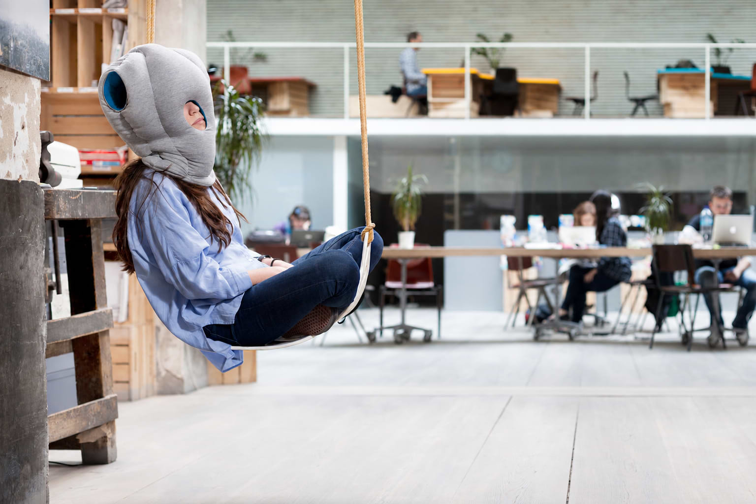 Woman relaxing in an Ostrichpillow napping pillow