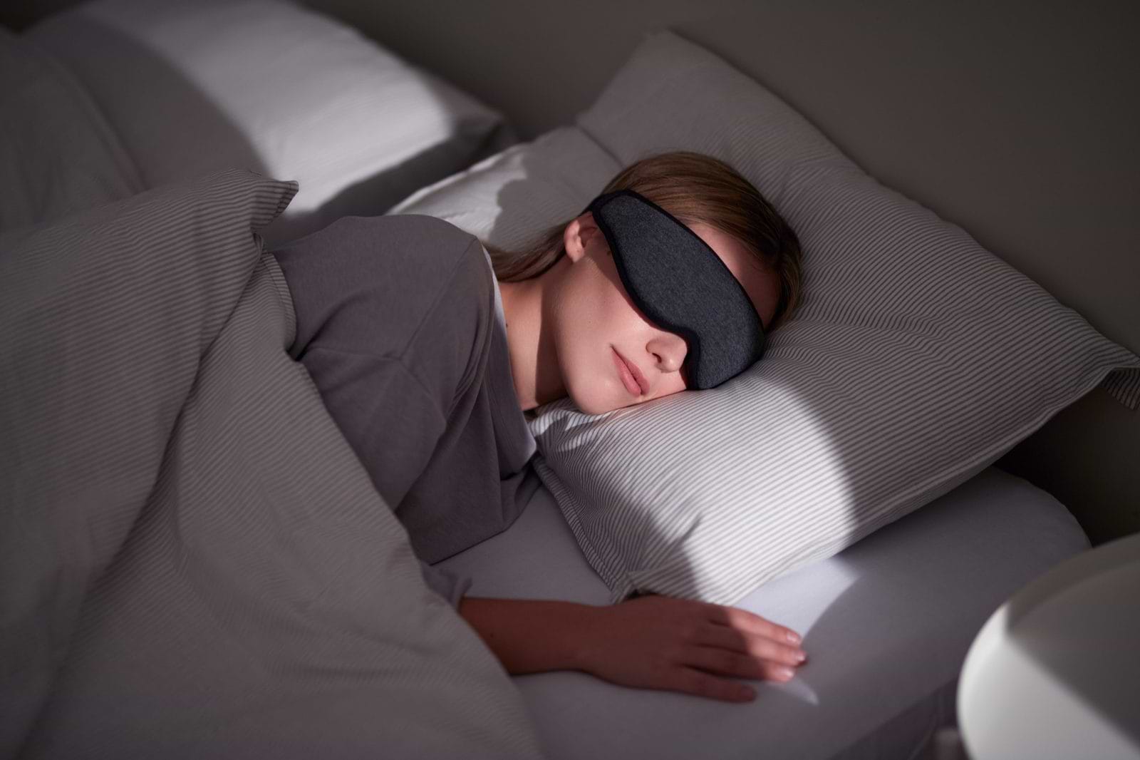 Contoured sleep mask worn by a side sleeper