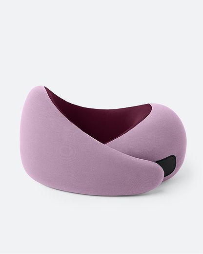 The Ostrichpillow Go Neck Pillow in the color Dusk, which has a dusty pink outer fabric and a burgundy inner lining, fastened by its adjustable strip.