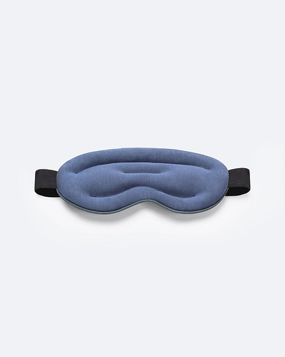 Top-down product shot of the Hot and Cold Eye Mask in Dark Night, showing its plush, contoured design and thick elastic strap.
