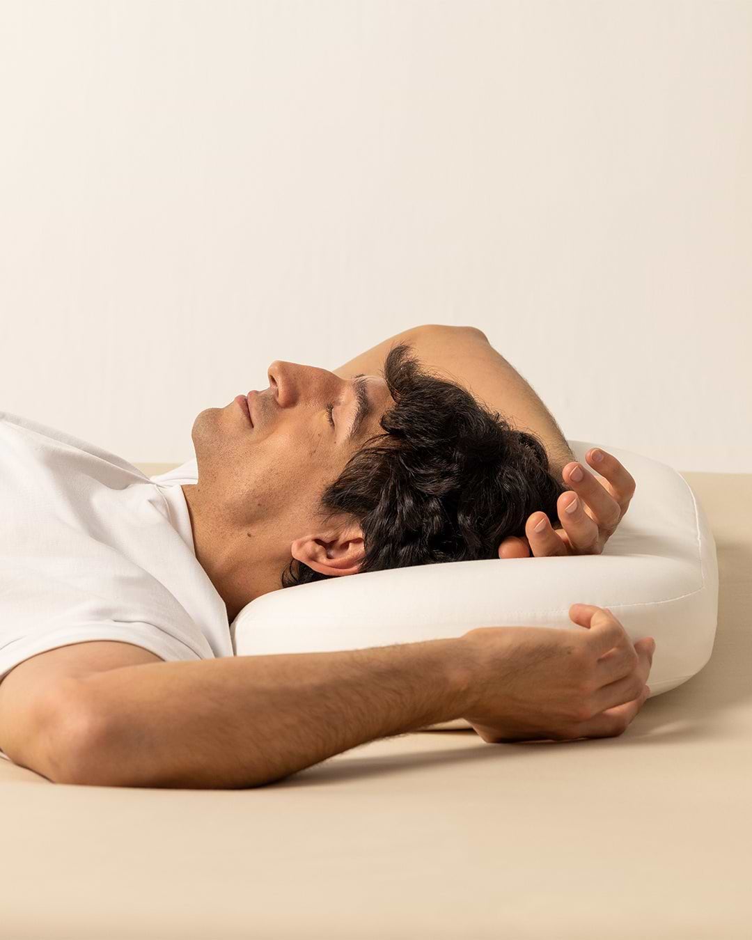 Man resting on his back with the Ostrichpillow memory foam Bed Pillow, showing neck support and ergonomic design for sleeping.