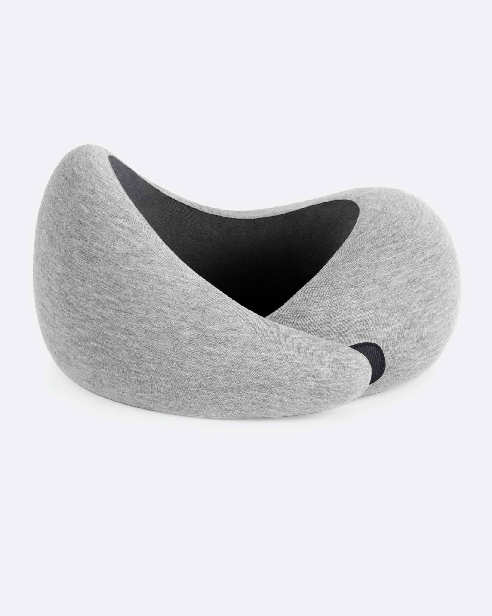 The Go Neck Pillow in the color Midnight Grey, which features a light grey outer fabric with a charcoal grey inner lining.