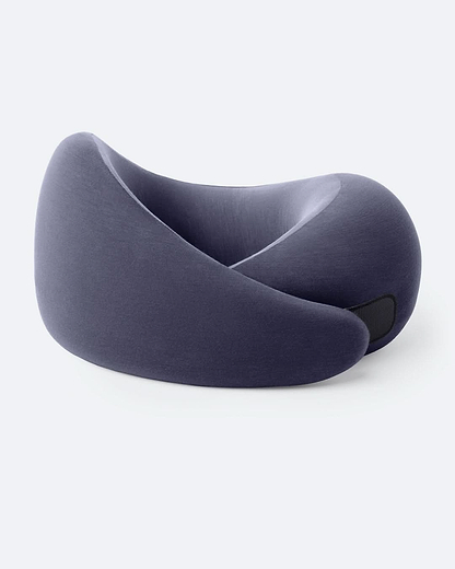 The Go Neck Pillow in color Night Walk, which features a dark purple outer fabric and lighter purple inner lining, fastened by its adjustable strip.