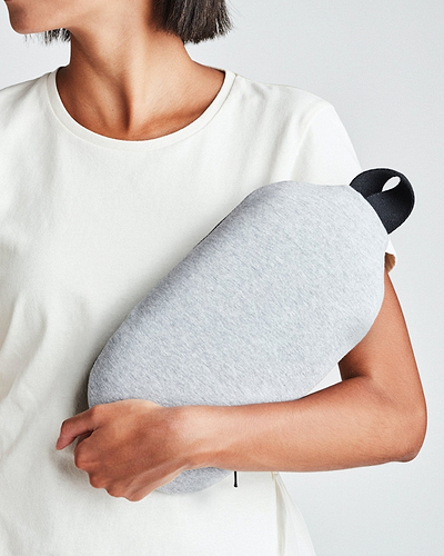 A woman holding the Ostrichpillow gray heatbag on her arm