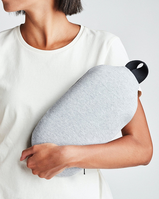 A woman holding the Ostrichpillow gray heatbag on her arm