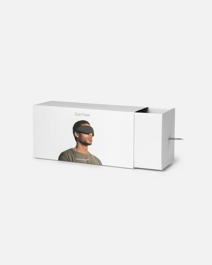 Minimalist white retail packaging for the Ostrichpillow Eye Mask in Eclipse Black, showcasing the sliding drawer mechanism partially open.
