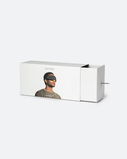 Minimalist white retail packaging for the Ostrichpillow Eye Mask in Eclipse Black, showcasing the sliding drawer mechanism partially open.