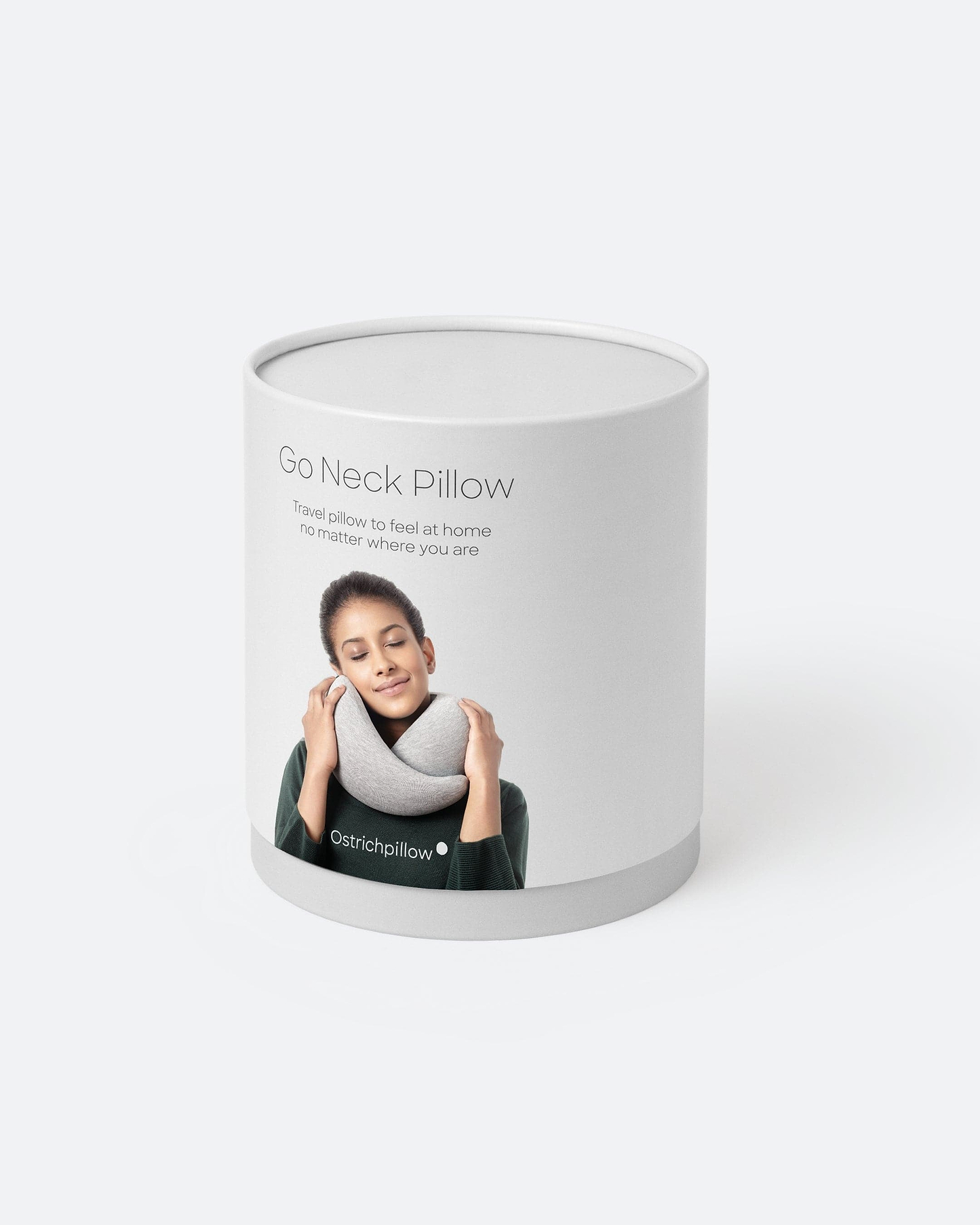 The retail packaging for the neck pillow for travel Ostrichpillow Go Neck Pillow, a cylindrical white cardboard box.