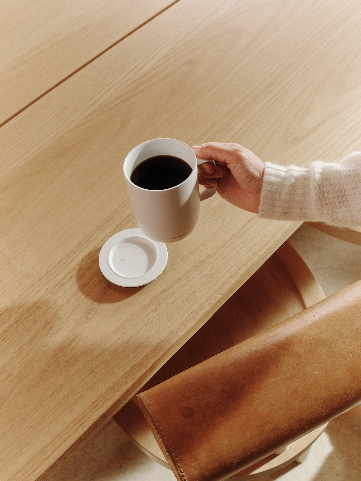 Lifting a white Ember Mug 3 from its included charging coaster