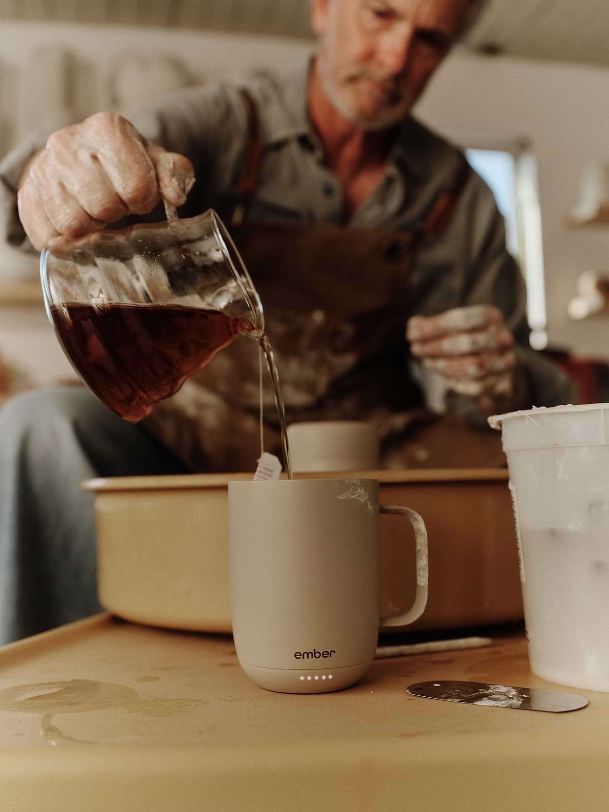 Pouring coffee into Ember Mug 3 in a pottery studio