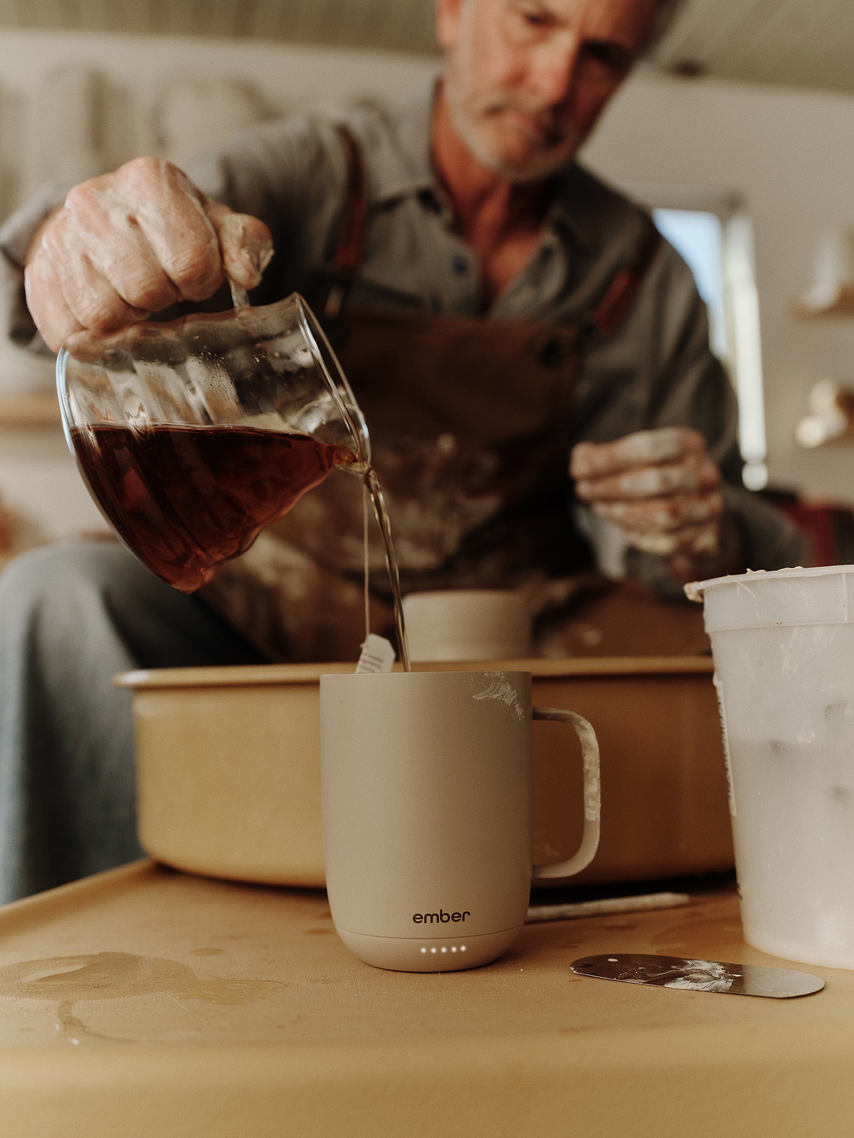 Pouring coffee into Ember Mug 3 in a pottery studio
