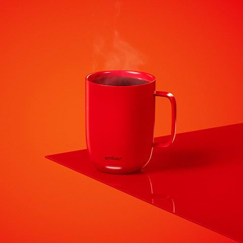 Ember(RED) Mug sits with steaming beverage.