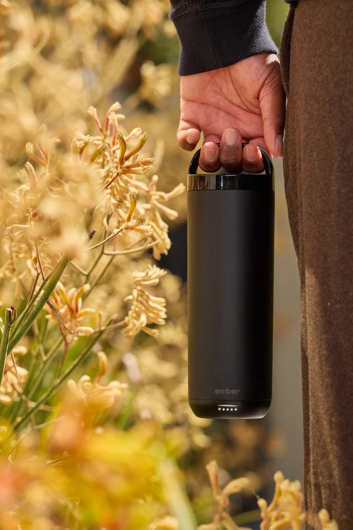 Carrying Black Tumbler 2 by its handle lid