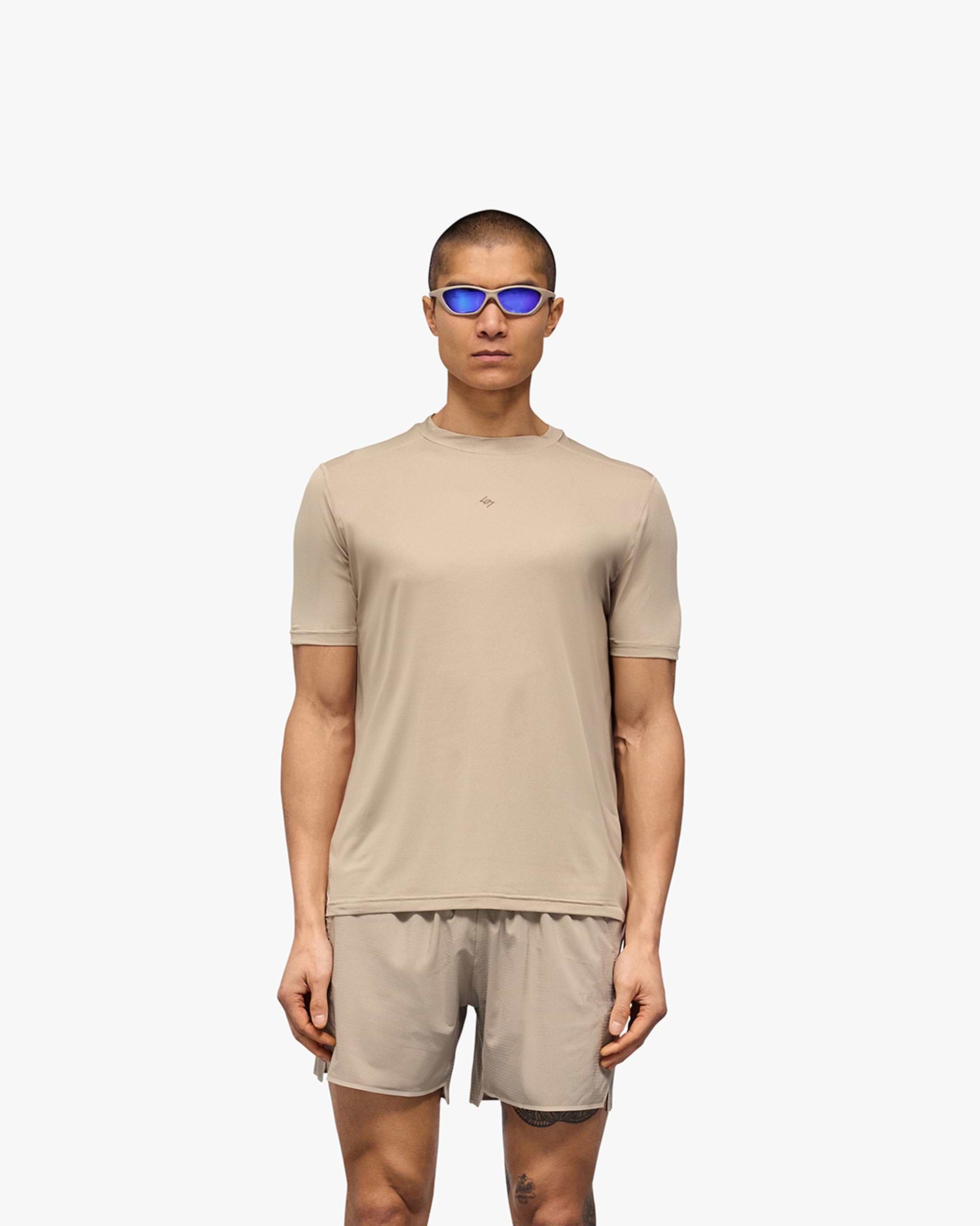 Man wearing a grey t-shirt on a plain white background | 247 Contour Run T-Shirt in Pebble | Breathable running t-shirt with contour back print | 247 T-Shirts | Represent Clo