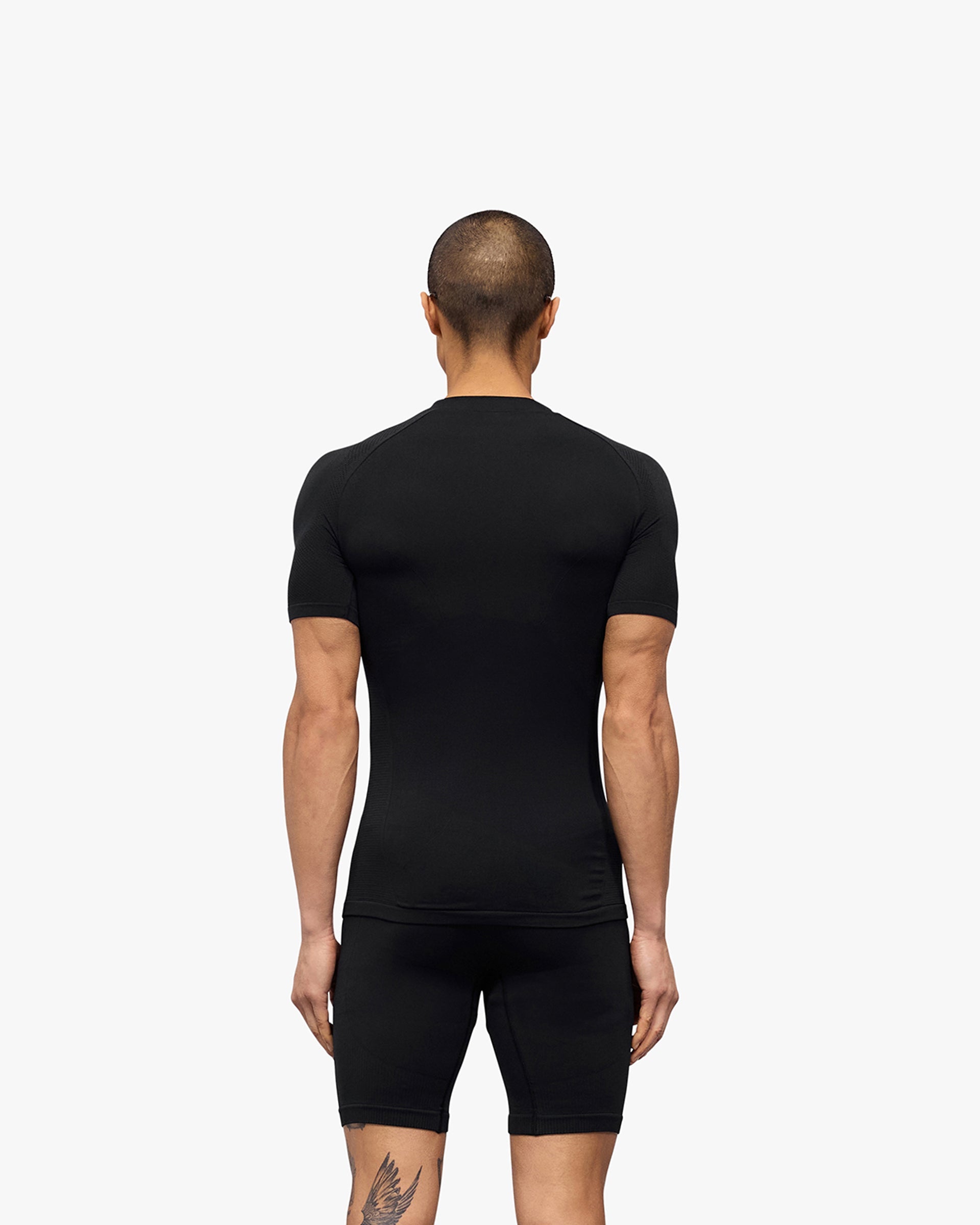 Man wearing a black seamless t-shirt on a plain white background | 247 DNA Seamless T-Shirt in Black | Seamless slim fit t-shirt for performance | 247 T-Shirts | Represent Clo