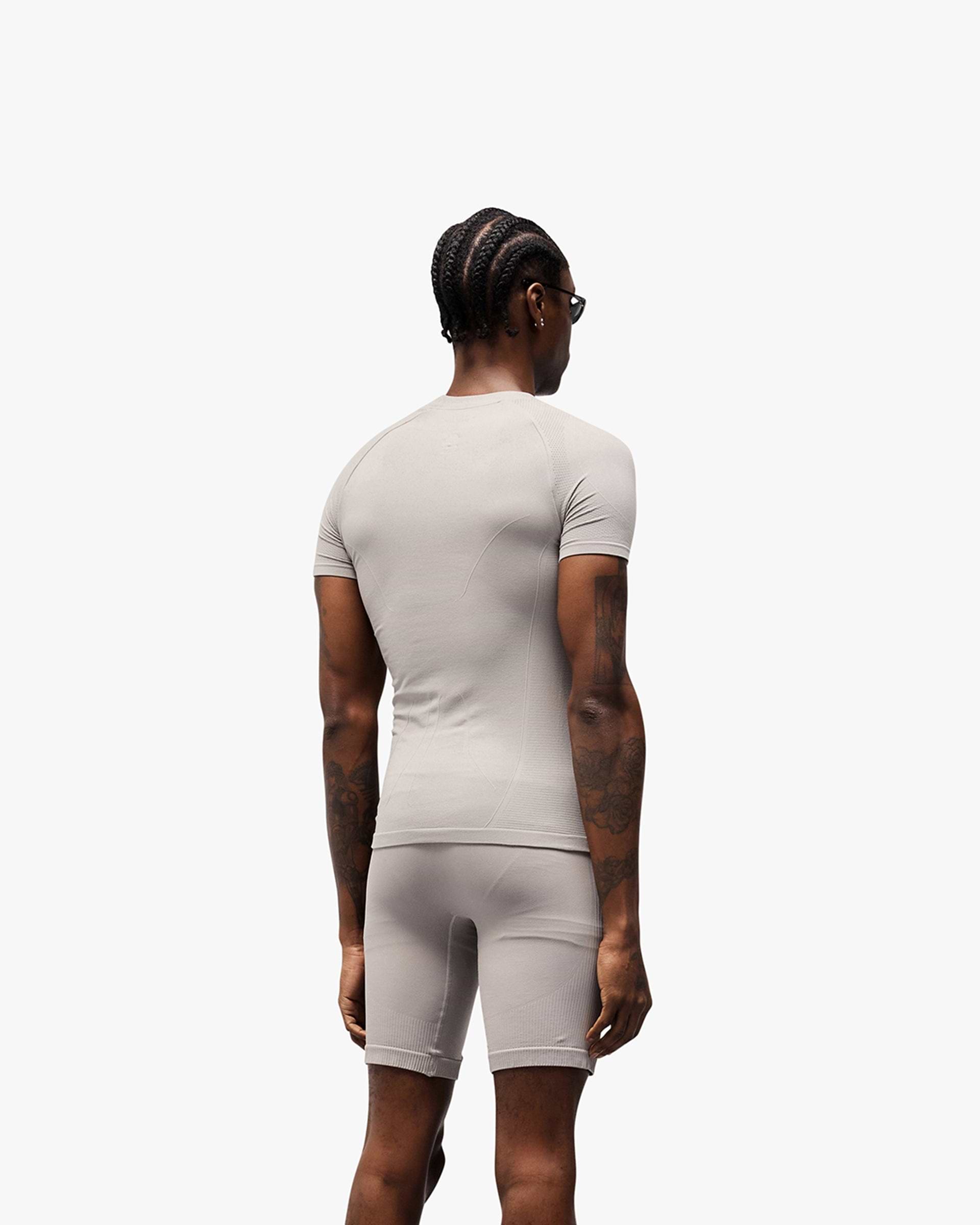 Man wearing a titanium t-shirt on a plain white background | 247 DNA Seamless T-Shirt in Titanium | Slim fit t-shirt with engineered knit zones | 247 T-Shirts | Represent Clo