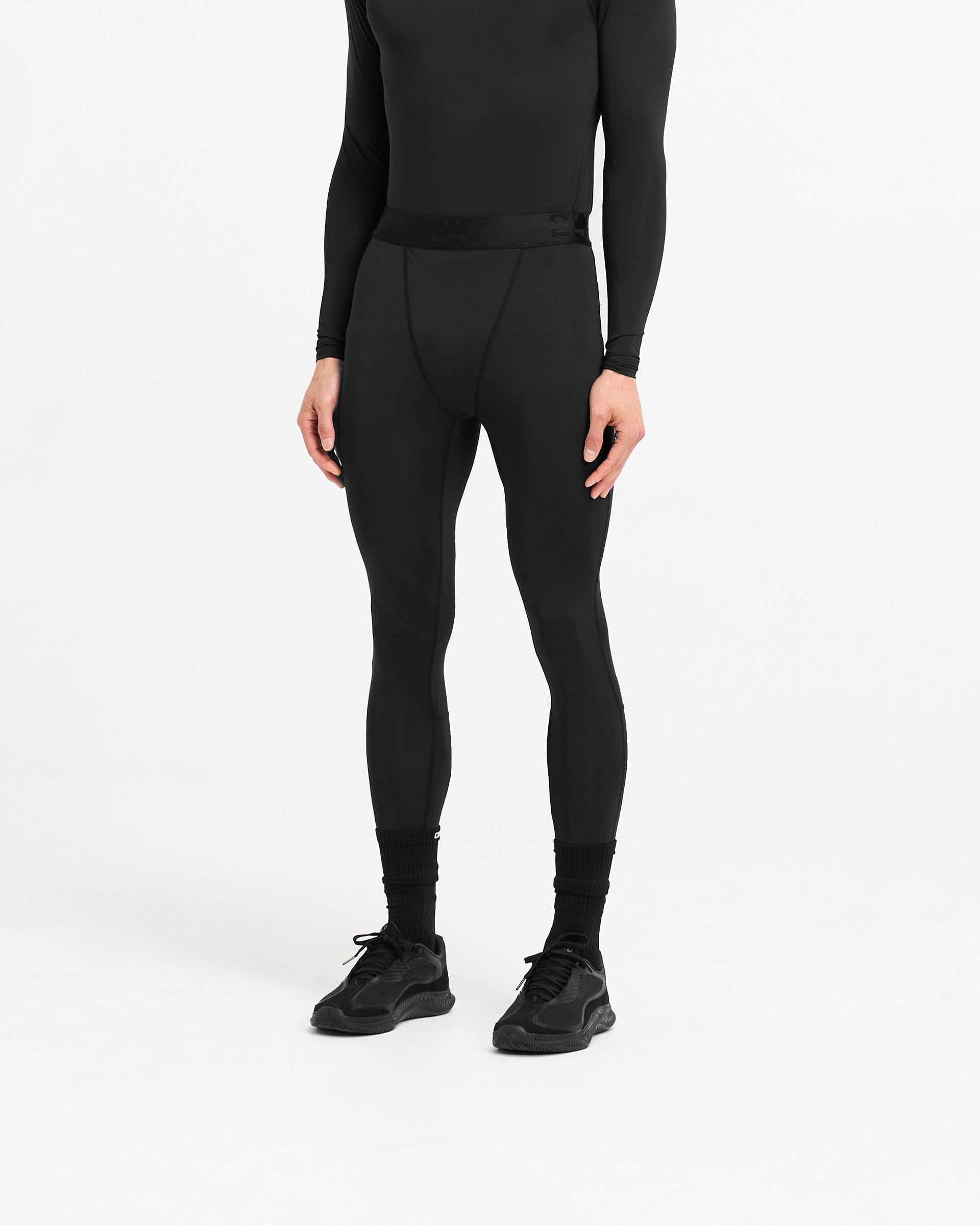 Man wearing black leggings on a plain white background | 247 Compound Legging in Black | Full length leggings with branded waistband | 247 Pants | Represent Clo