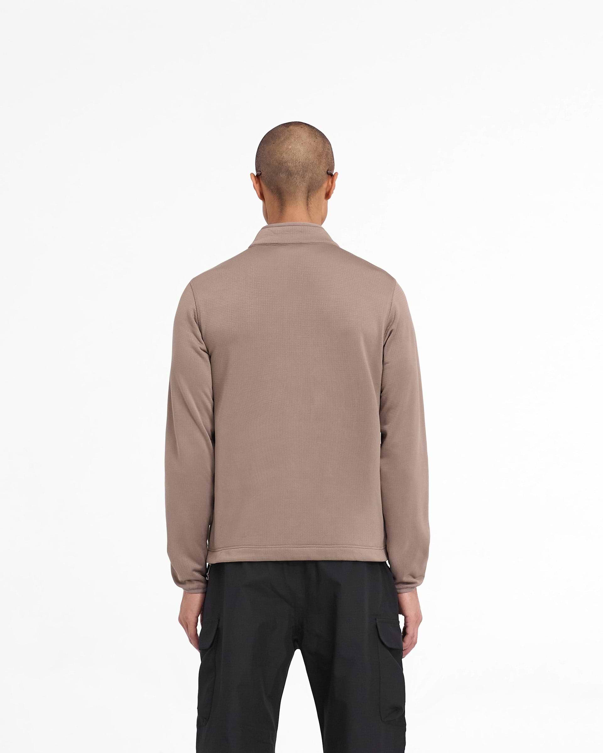 Man wearing a brown full zip fleece on a plain white background | 247 Full Zip Fleece in Umber | Fleece jacket with zip chest pocket and adjustable hem | 247 Outerwear | Represent Clo