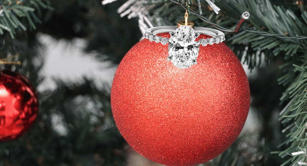Christmas ornament with en engagement ring surprise.