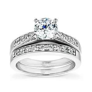  engagement ring Shown with a 1.0ct Round cut Lab-Grown Diamond with accenting stones on the band in recycled 14K white gold with matching wedding band