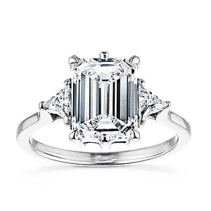 Gorgeous conflict free three stone engagement ring with 2ct emerald cut lab grown diamond center stone with triangle side stones set in 14k white gold band