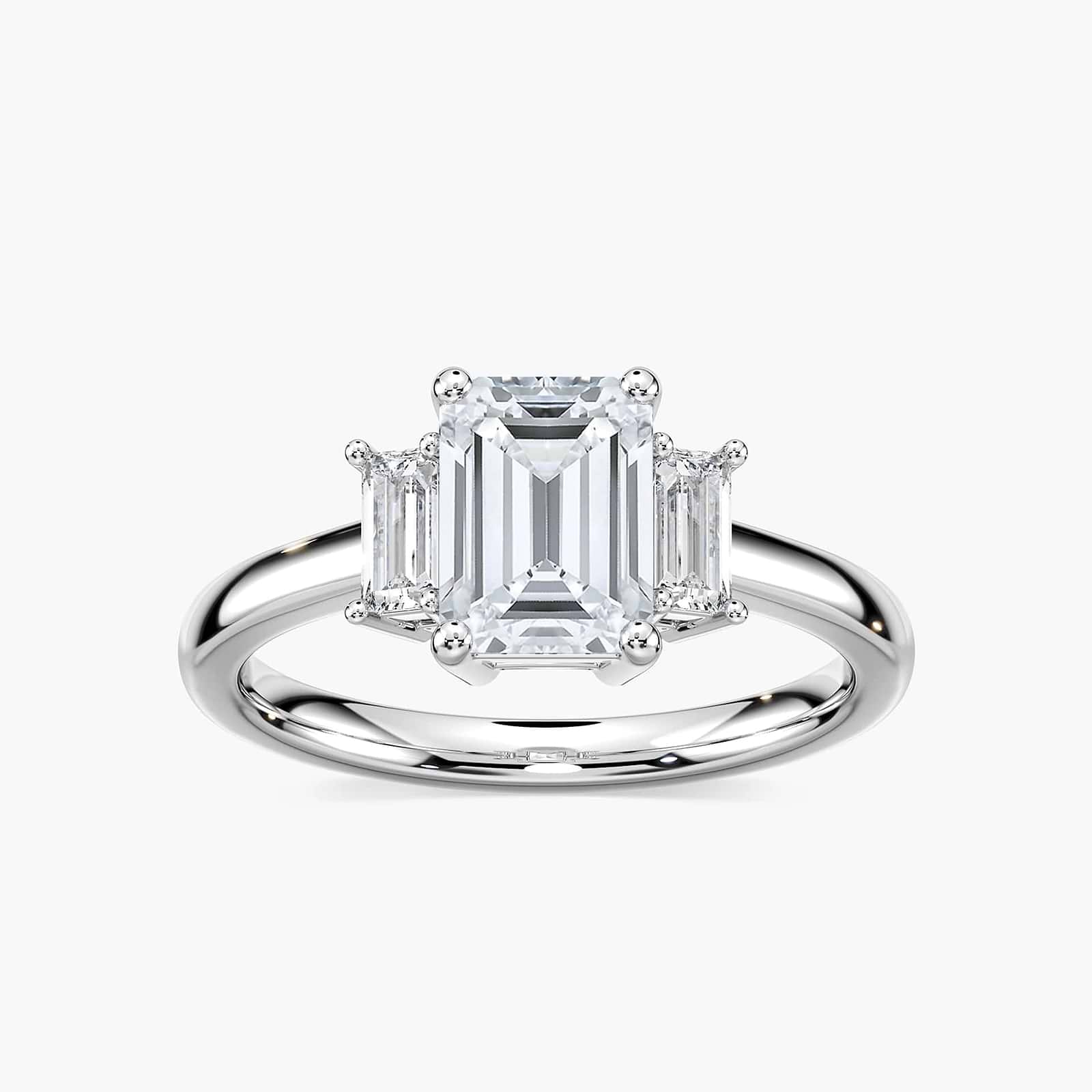 Shown with 1.75ct Emerald Cut Lab Grown Diamond in 14 White Gold|Ethical three stone engagement ring with 1.75ct emerald cut lab grown diamond center stone and two baguette cut diamond side stones in 14k white gold