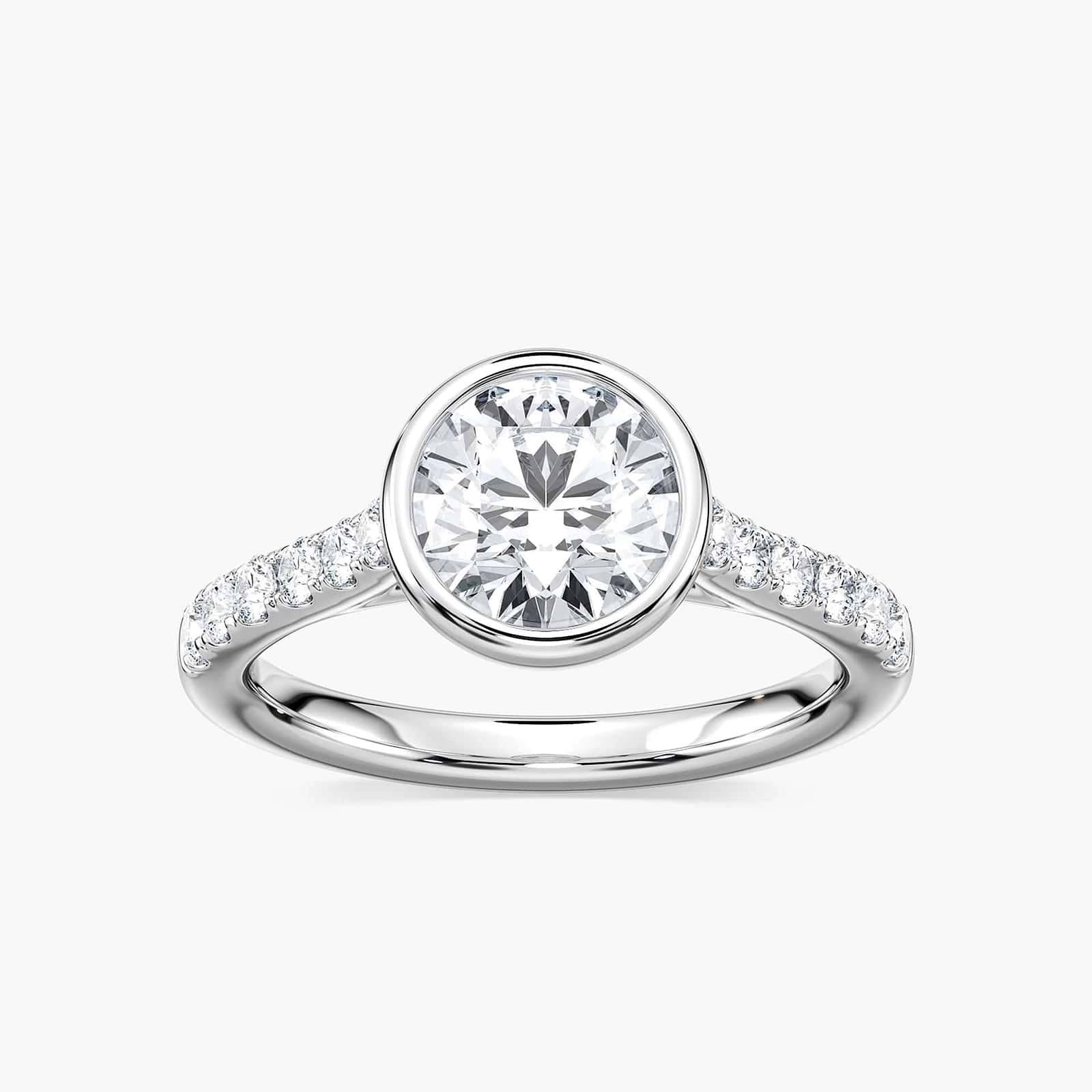 Shown with a bezel set 1.0ct Round cut Lab-Grown Diamond with accenting stones on the band in recycled 14K white gold | stackable engagement ring Shown with a bezel set 1.0ct Round cut Lab-Grown Diamond with accenting stones on the band in recycled 14K white gold