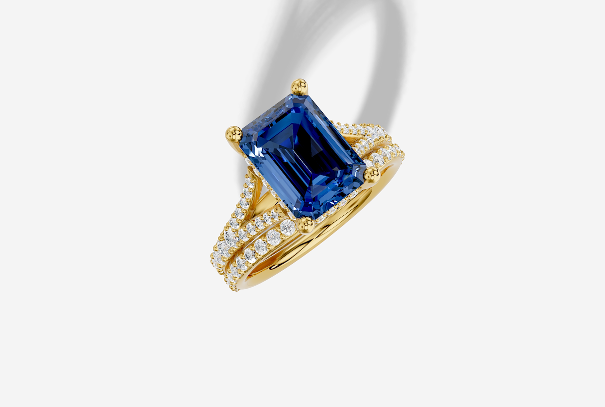 10.5 x 8.0 mm Emerald Cut Lab Grown Sapphire Shared Prong Split Shank Hidden Halo Engagement Ring in 18K Gold and 0.30 ctw Matching Band