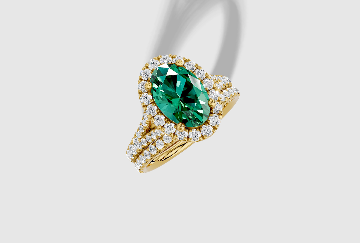 10.0 x 7.0 mm Oval Cut Lab Grown Emerald Micro Prong Split Shank Halo Engagement Ring in 18K Gold and 0.31 ctw Matching Band