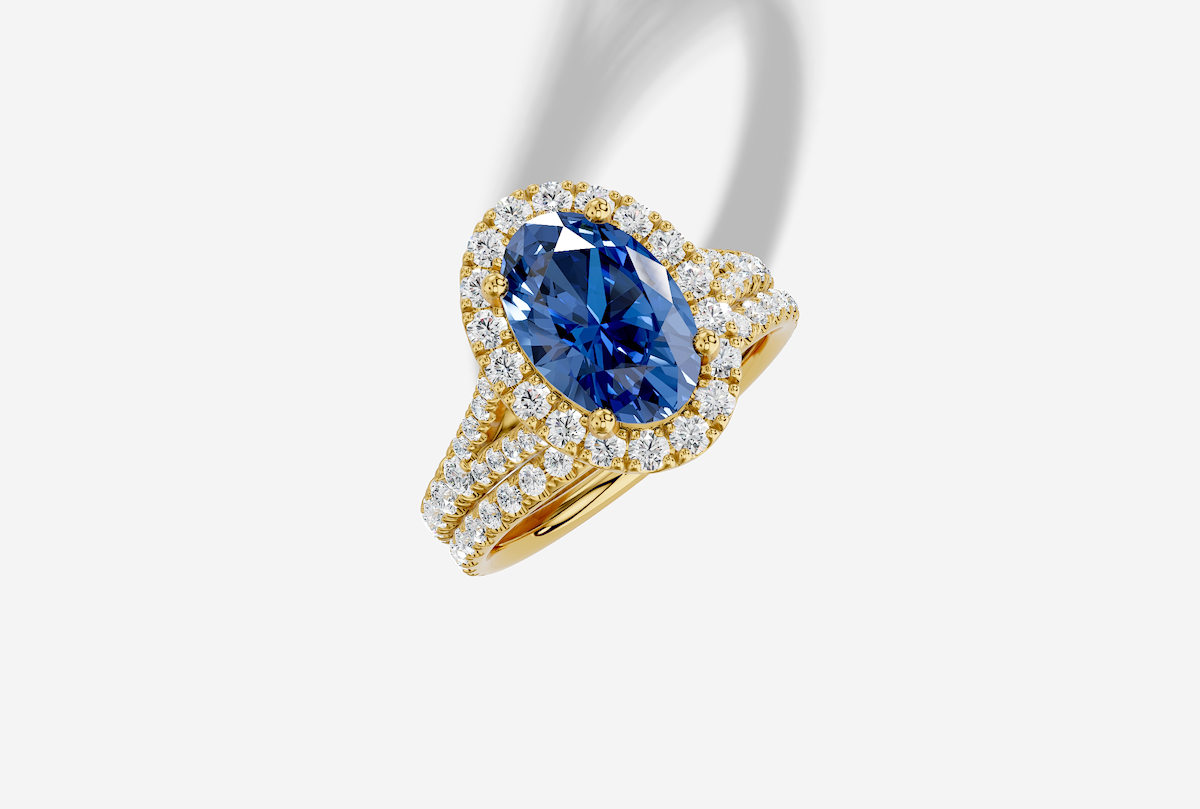 10.0 x 7.0 mm Oval Cut Lab Grown Sapphire Micro Prong Split Shank Halo Engagement Ring in 18K Gold and 0.31 ctw Matching Band