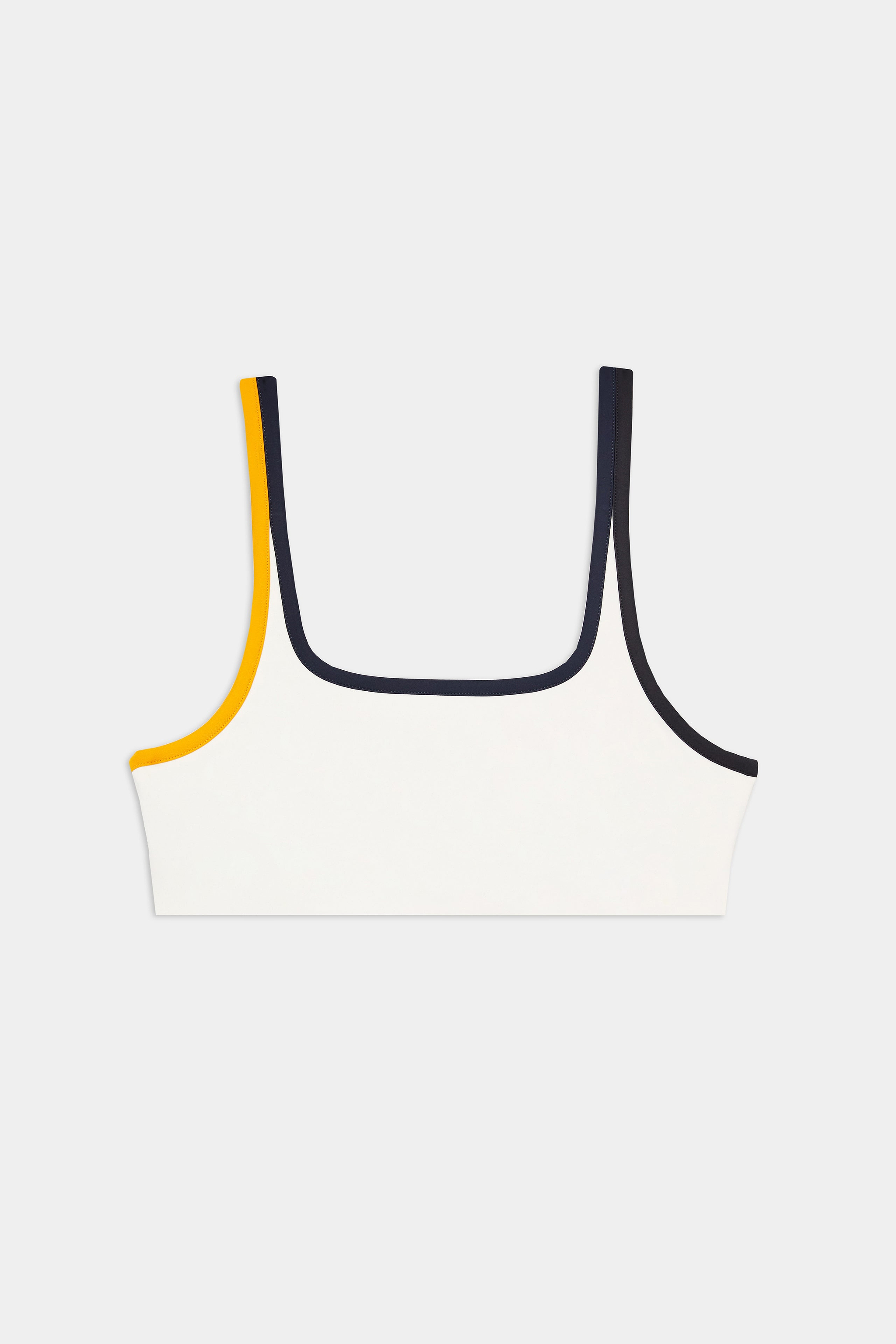 A white cropped tank top with square neckline, featuring contrasting dark trim on the right strap and yellow trim on the left strap, laid flat on a plain background.