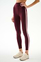 A person is wearing the SPLITS59 Clare High Waist Rigor 7/8 leggings in Dark Cherry/Blush, featuring a high-waisted sculpting fit with light pink side stripes and paired with beige sneakers, standing against a plain white background. These workout leggings combine comfort and style.