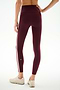 A person wearing SPLITS59 Clare High Waist Rigor 7/8 leggings in Dark Cherry/Blush, featuring a sculpting fit and white side stripe, paired with beige sneakers, standing on a white background and shown from the back.