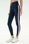 A person wearing SPLITS59 Margot Rigor Legging in Indigo/Blush and white athletic shoes stands against a plain background.