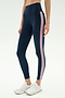 A person wearing SPLITS59 Margot Rigor Legging in Indigo/Blush and white athletic shoes stands against a plain background.