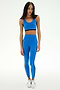 Model wearing the SPLITS59 Ella High Waist Airweight 7/8 leggings and matching sports bra in Classic Blue/Indigo with black stripes, paired with white sneakers, set against a plain white background.
