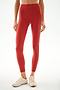 A person wears SPLITS59 Emerson Airweight High Waist 7/8 - Terracotta/Creme leggings with a gold side stripe and light athletic shoes against a white background.