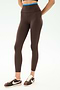 A person wears SPLITS59 Dual High Waist Airweight 7/8 leggings in Dark Chocolate/Classic Blue, featuring a blue waistband, paired with brown Nike sneakers, standing against a plain white background.