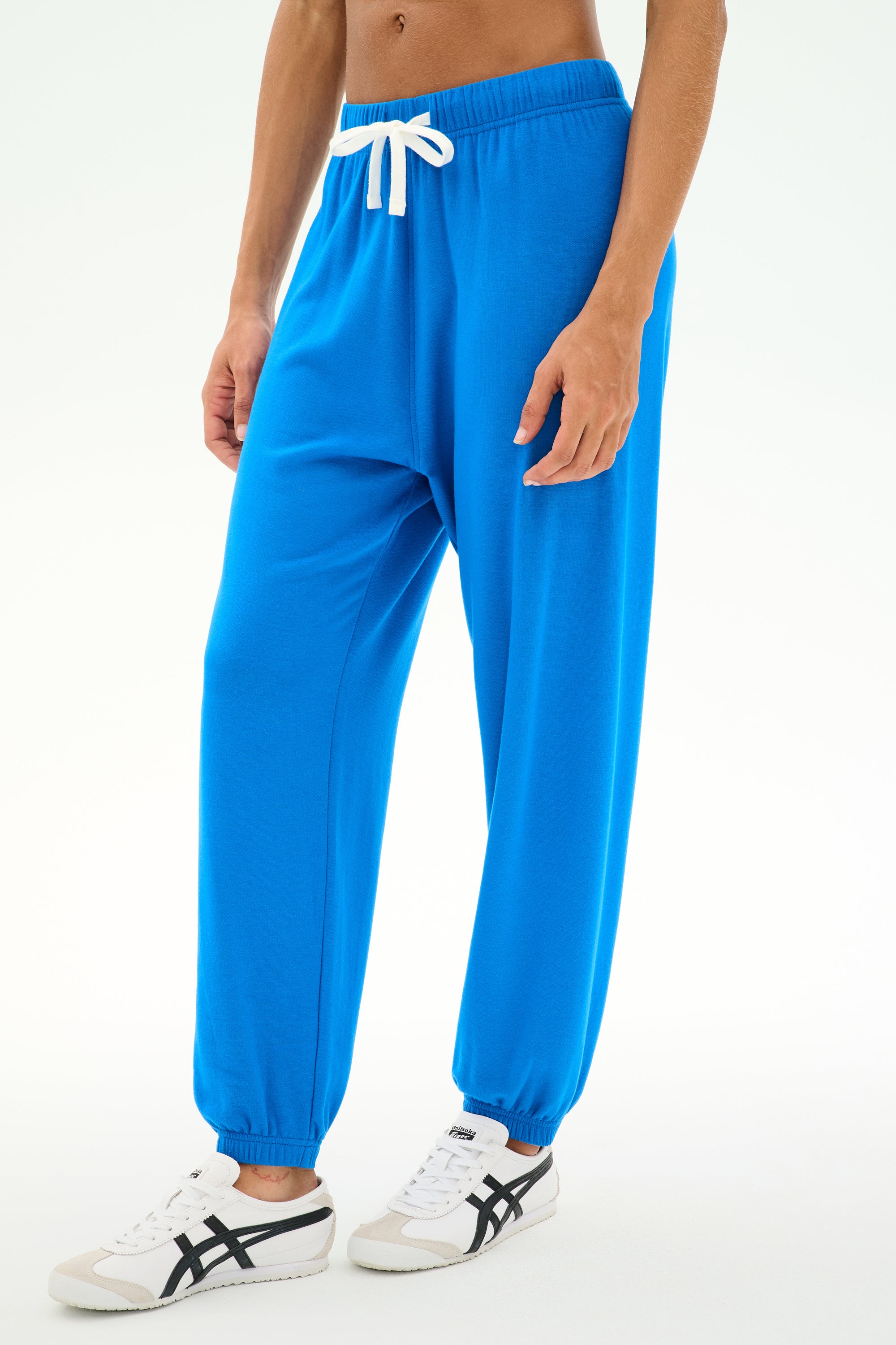 Wearing the SPLITS59 Andie Oversized Fleece Sweatpant in Classic Blue—featuring a relaxed fit with a white drawstring—paired with white sneakers, this look is ideal for cool weather workouts. Made in Los Angeles.