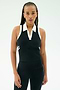 A woman with long braids wears the SPLITS59 Austin Airweight Crop Polo in Black/White, standing against a plain light background.