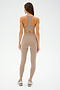 A person in taupe athletic wear and sneakers, showcasing SPLITS59 Chevron Airweight High Waist 7/8 leggings in Latte/Indigo, stands with their back to the camera against a plain white background.