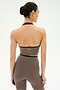 A person with dark hair in a bun faces away against a plain white background, wearing the SPLITS59 Rory Airweight Halter Bralette in Lentil/Black and matching stretch leggings.