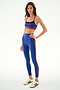 Model wears the SPLITS59 Scottie Airweight Bra - Cobalt/Indigo with matching leggings and white athletic shoes against a white background.