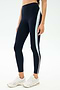 A person wears SPLITS59 Emerson Airweight High Waist leggings in Indigo/Dove Grey—navy with a vertical light blue and white stripe—ideal for Pilates, paired with white athletic shoes, standing against a plain background.