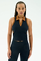 A person with long braided hair wears the SPLITS59 Austin Airweight Crop Polo in Indigo/Honey, paired with matching navy spandex leggings, standing against a plain light background.
