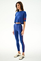 Woman wears the SPLITS59 Djuna Oversized Crop Jersey Tee - Cobalt/Terracotta with high-waisted leggings and white sneakers, standing against a plain white background.